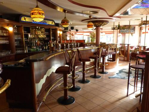 a bar with a row of bar stools at Hotel MyLord in Soltau