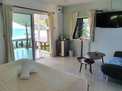 a bedroom with a bed and a view of the ocean at Blue Bay Bungalow in Ko Samed