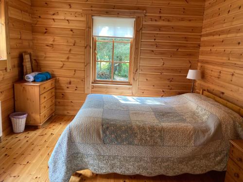 a bedroom with a bed in a wooden room at Riverside log cabin in Ballyconnell