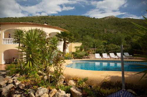 a resort with a swimming pool with chairs and a mountain at Sueño Grande in Lliber