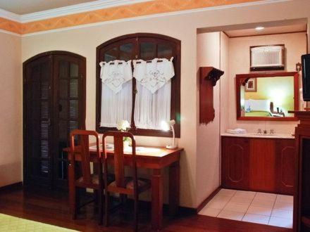 a dining room with a table and chairs and a mirror at Hotel Dom Otto in Vespasiano