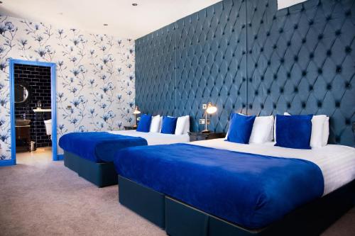 two beds in a room with blue and white walls at The Coal Exchange Hotel in Cardiff