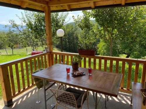 une terrasse couverte en bois avec une table et des chaises. dans l'établissement Etno kuća Mladenović, à Raška