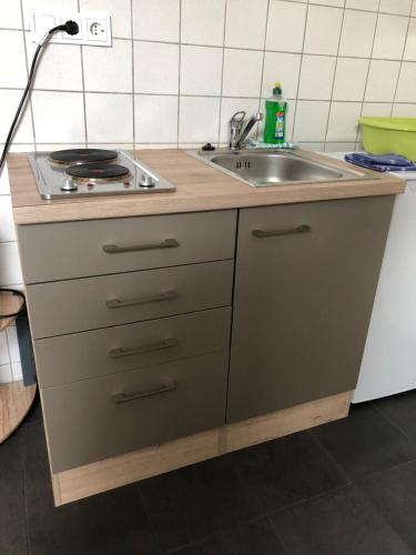 a kitchen with a sink and a stove at FeWo Kerstin Rossbacher in Solingen