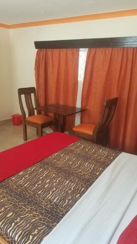 a bedroom with a bed and two chairs and a table at Ocean View Nyali Boutique Hotel in Nyali
