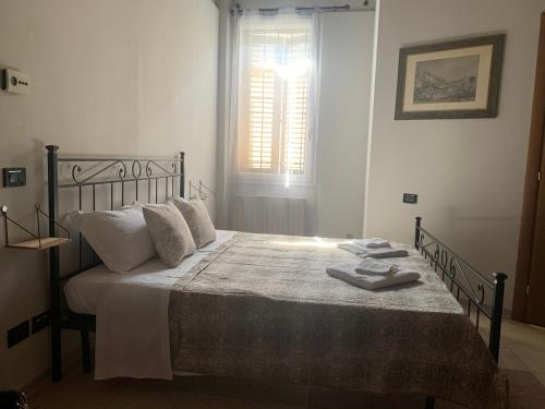 a bedroom with a bed with white sheets and a window at Le Stanze sul Po in Ferrara