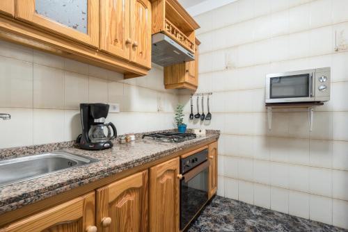 una cocina con fregadero y microondas en Casa del Molino, en Icod de los Vinos
