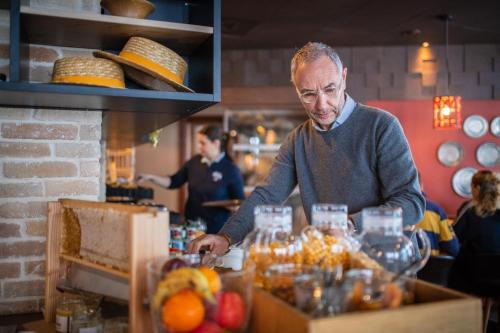 un homme debout à un comptoir préparant de la nourriture dans l'établissement Le Hameau du Kashmir, à Val Thorens
