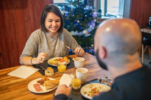 une femme assise à une table avec un homme mangeant de la nourriture dans l'établissement Le Hameau du Kashmir, à Val Thorens