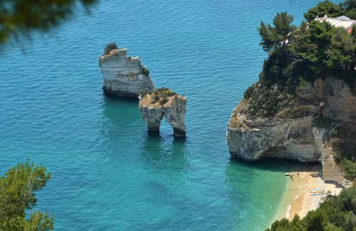 two large rocks in the water next to a beach at B&B Home Sweet Home - Affitti Brevi Italia in Manfredonia