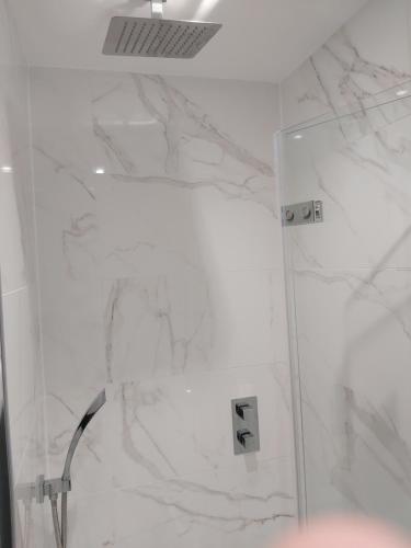 a bathroom with a shower with white marble at Dean Park Hotel in Kirkcaldy