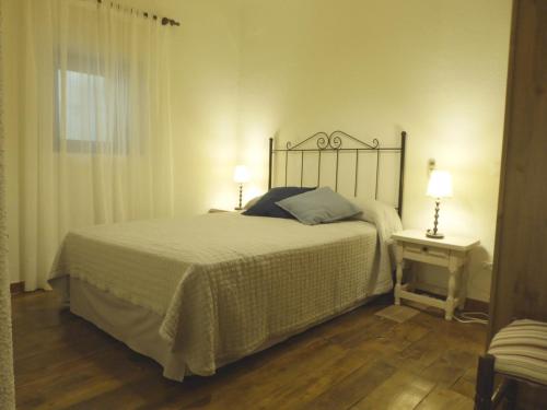 sypialnia z łóżkiem, 2 lampami i oknem w obiekcie La Serrana de la Vera Casa Rural TR-CC-00366 w mieście Garganta la Olla