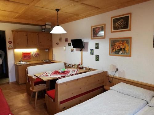 a room with two beds and a table in it at Casa Focobon - presso Sussy residence in Falcade
