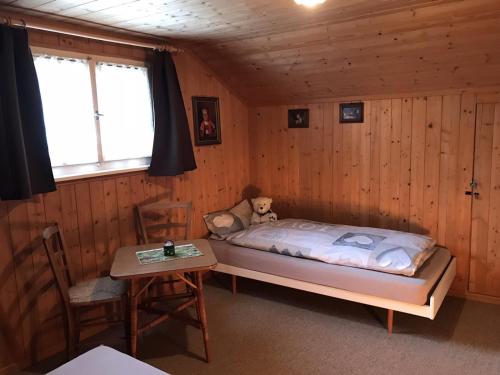 a bedroom with a bed and a teddy bear in it at Appenzellerland - Ferienhaus "Bömmeli" in Hundwil