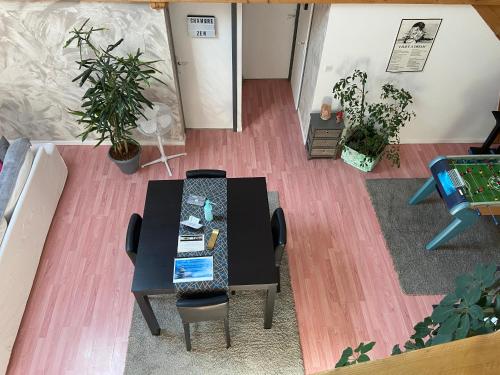 une table et des chaises dans une pièce avec des plantes dans l'établissement Maison d'hôtes Zen, à Arbin