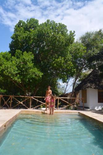 a woman and a child standing in a swimming pool at The Island - Pongwe Lodge in Pongwe