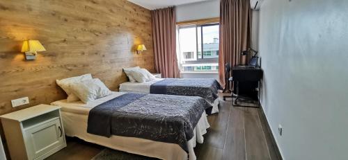 ポルティマンにあるApartment Charmeのベッド2台と窓が備わるホテルルームです。
