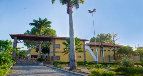 a yellow house with palm trees in front of it at Bonito Plaza Hotel in Bonito