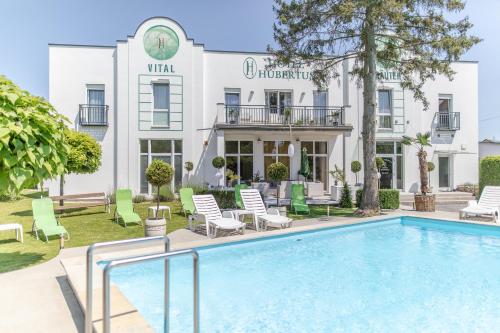 a hotel with a swimming pool in front of a building at Hotel Hubertus in Söchau