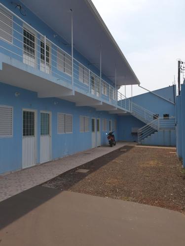 a blue building with a motorcycle parked next to it at Kitnet Camiloca in Campo Grande