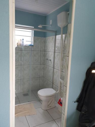 a bathroom with a toilet and a shower at Kitnet Camiloca in Campo Grande