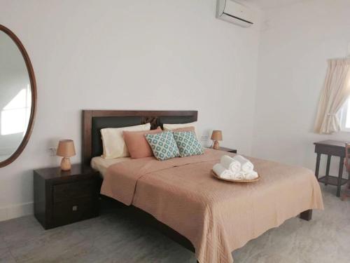 1 dormitorio con 1 cama grande y espejo en Ulu Rhu Villa, en Tanjung Rhu