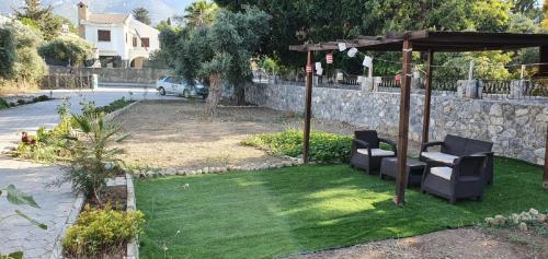 a gazebo with two chairs and a table at Suluca Homes in Kérynia