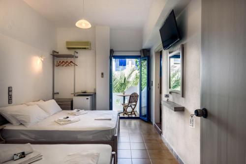 a hotel room with two beds and a television at Giannis studio Agia Roumeli in Agia Roumeli