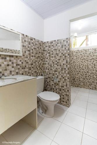 a bathroom with a toilet and a sink and a mirror at Pousada Angatu Arraial - Rua mucugê in Arraial d'Ajuda