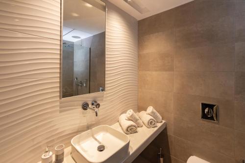 a bathroom with a sink and a mirror at Zoes Hotel & Suites in Faliraki