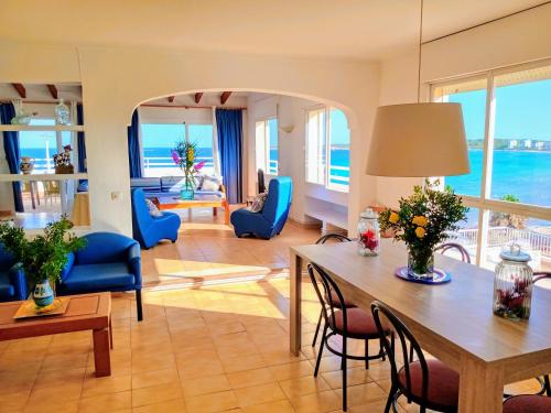 Apartamentos Villa Margarita في كالا مييور: غرفة معيشة مع طاولة وكراسي زرقاء