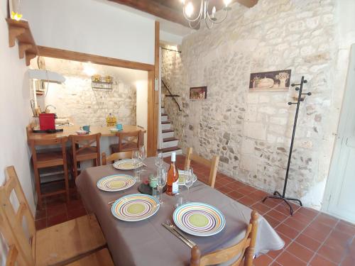 - une salle à manger avec une table et des assiettes dans l'établissement Charmante maison arlésienne à l'ombre des Arènes, de 2 à 5p, à Arles