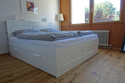 a large white bed in a room at Nemos Paradies - TOP Lage am See und Sbahn in Pöcking