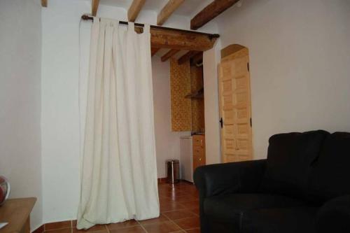 sala de estar con sofá y cortina blanca en Cueva Santa Cruz, en Alicante