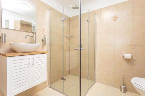 W łazience znajduje się szklana kabina prysznicowa i umywalka. w obiekcie PORT CITY HAIFA - BAT GALIM 25 mtrs from the beach & Rambam w mieście Bat Gallim