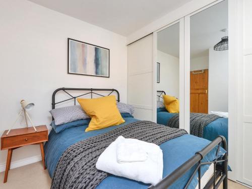 a bedroom with two beds and a mirror at The Willows in Melton Mowbray