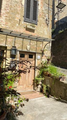 a stone building with a large wooden door at La Magione dei Todaro in Borgo a Buggiano