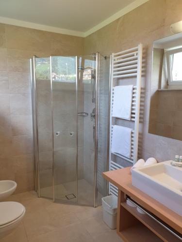 a bathroom with a shower and a sink at Hotel Garni Herz in Tirolo
