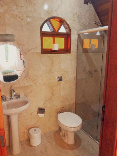 a bathroom with a toilet and a sink and a shower at Pousada Vila Lubia - Chalés Monte Verde in Monte Verde