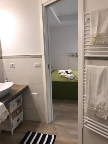 a bathroom with a bed and a sink and a mirror at Casa Vacanza Cundari in Castelmola