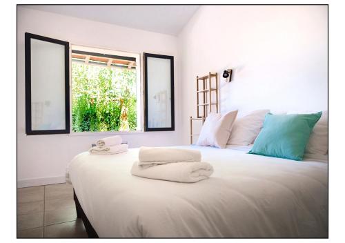 1 dormitorio con 1 cama blanca grande y toallas. en Domaine Cassevinha, en Gauriac