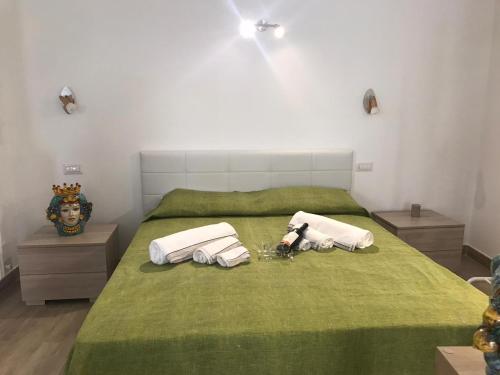 a bedroom with a green bed with towels on it at Casa Vacanza Cundari in Castelmola