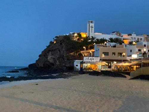 een uitzicht op een strand in de nacht met een gebouw bij Morrojable Luxury Beach Apartments in Morro del Jable