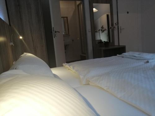 a white bed in a room with a mirror at Pension Der Kretaner in Berlin