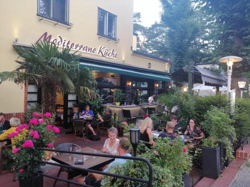 a group of people sitting outside of a restaurant at Pension Der Kretaner in Berlin