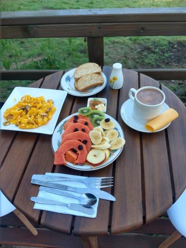 a table with plates of food and a cup of coffee at Libélula Glamping con jacuzzi in Duitama