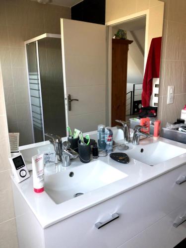 un bagno bianco con lavandino e grande specchio di O Bord de la mer a Saint-Pierre-Quiberon
