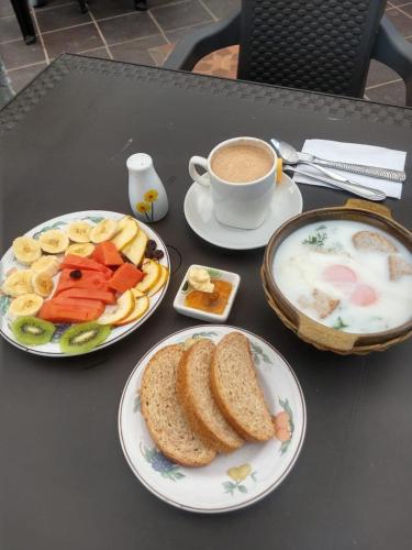 a table with two plates of food and a cup of coffee at Libélula Cabaña- Alojamiento rural in Duitama
