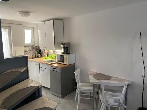 a small kitchen with a table and a microwave at Romantisches Gästezimmer - Zentralgelegen in Wehrheim