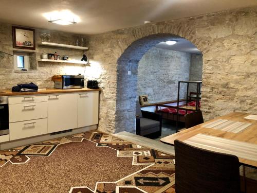a kitchen with a stone wall and a table at Kauba 6a apartment in Kuressaare